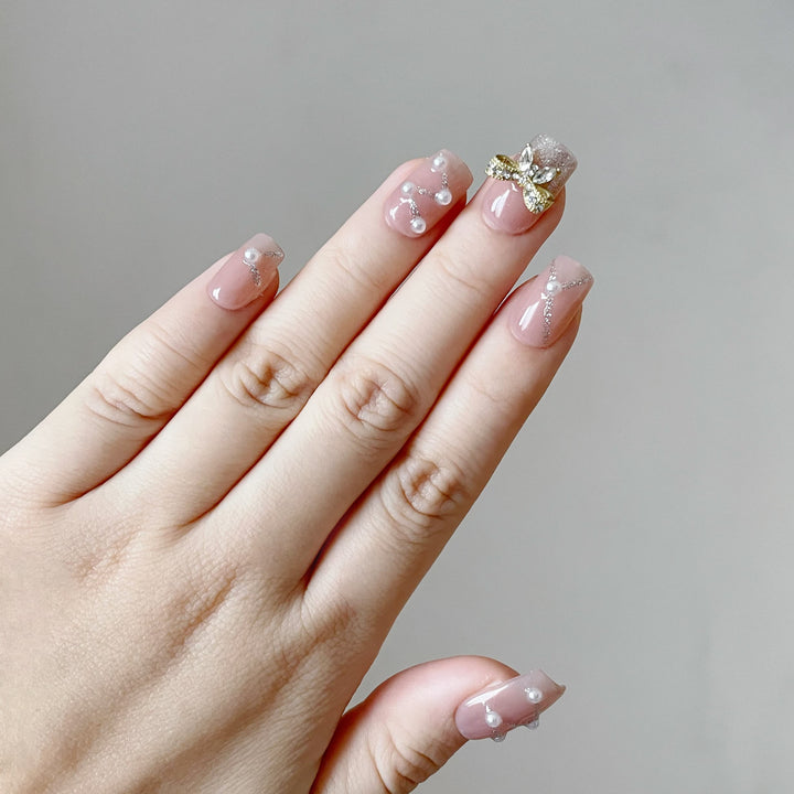 classy nude press on nails with pearls and bows